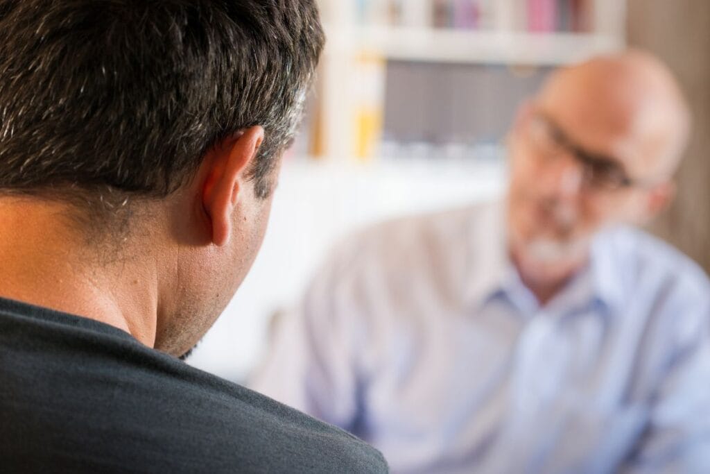 A counselor meeting with a young man in a counseling session